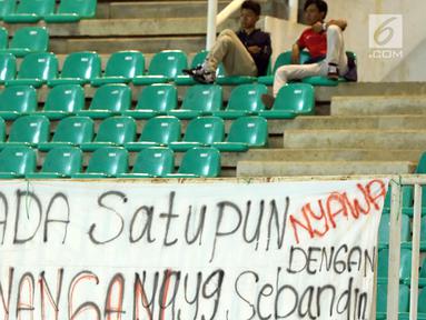 Suporter menyaksikan laga Indonesia U-19 melawan China U-19 pada PSSI 88th U-19 International Tournament di Stadion Pakansari, Selasa (25/9). Suporter membentangkan spanduk keprihatinan atas aksi kekerasan yang terjadi. (Liputan6.com/Helmi Fithriansyah)