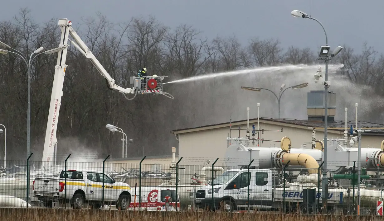 Petugas pemadam kebakaran menyemprotkan air di pusat pipa gas di Baumgarten, Austria, (12/12). Ledakan tersebut belum diketahui secara pasti apa penyebabnya. (AP Photo/Ronald Zak)