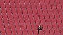 Seorang wanita duduk di tribun penonton yang kosong dalam pertandingan Liga Jerman antara Augsburg melawan Bayer Leverkusen, Minggu (21/2/2021). (Foto: AFP/Berbagai Sumber/Christof Stache)