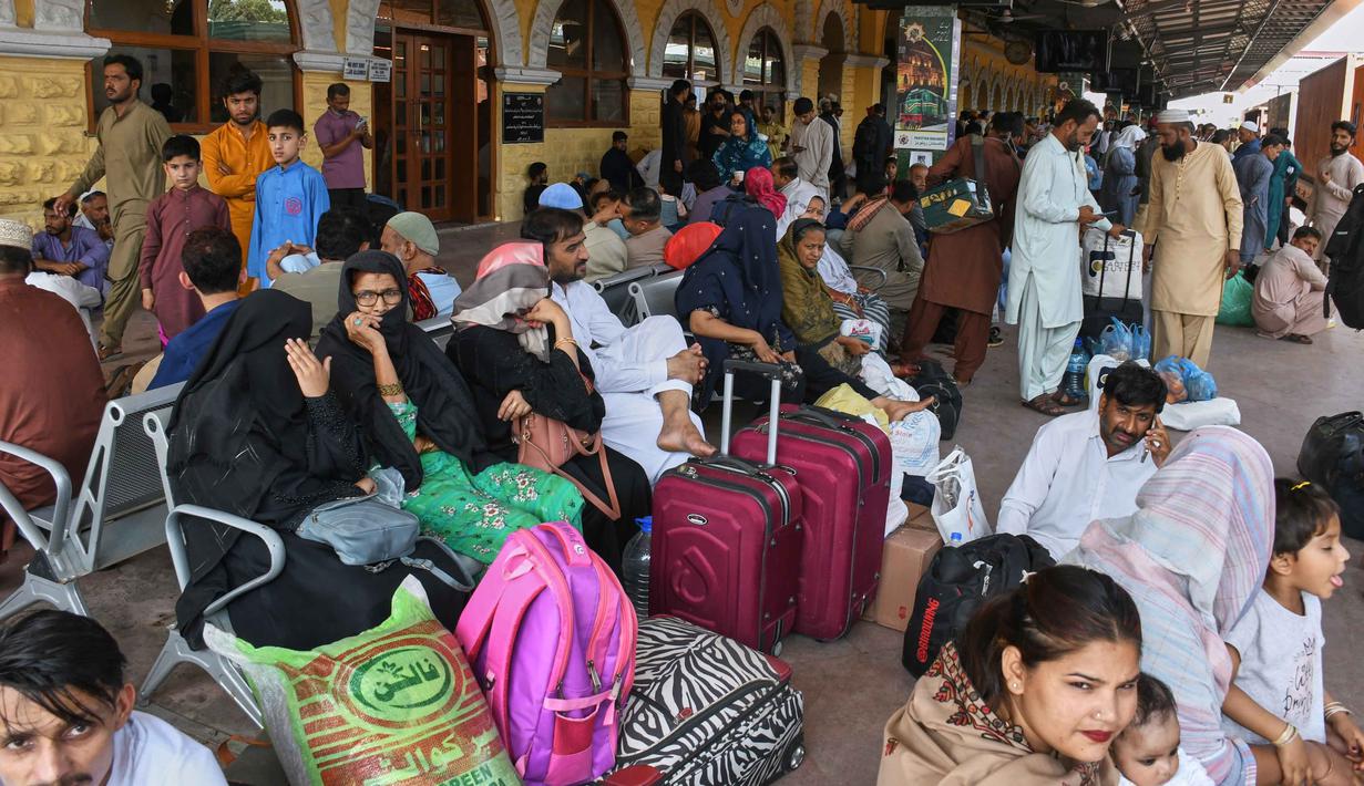 Kereta pun penuh sesak, bahkan beberapa penumpang, meski berbahaya, terpaksa duduk di atas atap. Tampak dalam foto, orang-orang menunggu untuk naik kereta penumpang untuk pulang ke kampung halaman untuk Hari Raya Idul Fitri yang akan datang, sekaligus menandai berakhirnya bulan suci Ramadan, di sebuah stasiun kereta api di Karachi, Pakistan, Selasa 17 Maret 2026. (AP Photo/Ali Raza)