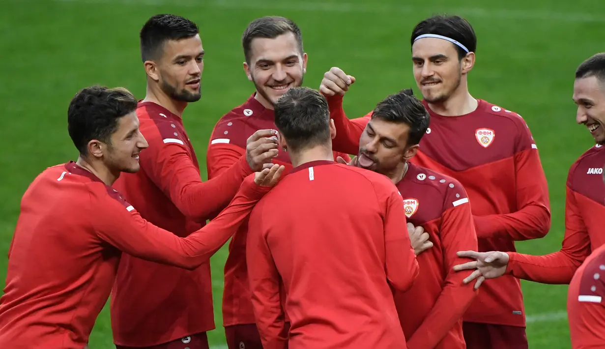 Pemain Makedonia Utara bercanda disela menghadiri sesi latihan pada malam pertandingan play-off Piala Dunia 2022 di stadion Dragao di Porto, Senin (28/3/2022). Makedonia Utara akan menantang Portugal pada Rabu, 30 Maret 2022 dini hari WIB. (MIGUEL RIOPA/AFP)