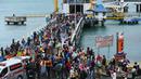 Para pengungsi turun dari kapal ferry di Pelabuhan Bakauheni, Lampung, Rabu (26/12). Aktivitas gunung berapi anak Krakatau yang mengakibatkan gelombang tsunami 22 Desember lalu memaksa belasan ribu orang mengungsi. (AFP Photo/Mohd Rasfan)