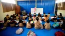 Seorang guru mengajar murid tanpa menggunakan meja dan kursi sekolah, di SDN Bojong Nangka 02, Kabupaten Bogor, Jawa Barat, Kamis (16/2/2023). Sudah lebih dari dua pekan, murid-murid di tiga ruang kelas  menerapkan kegiatan belajar mengajar beralas karpet karena belum tersedianya bangku dan meja. (merdeka.com/Arie Basuki)