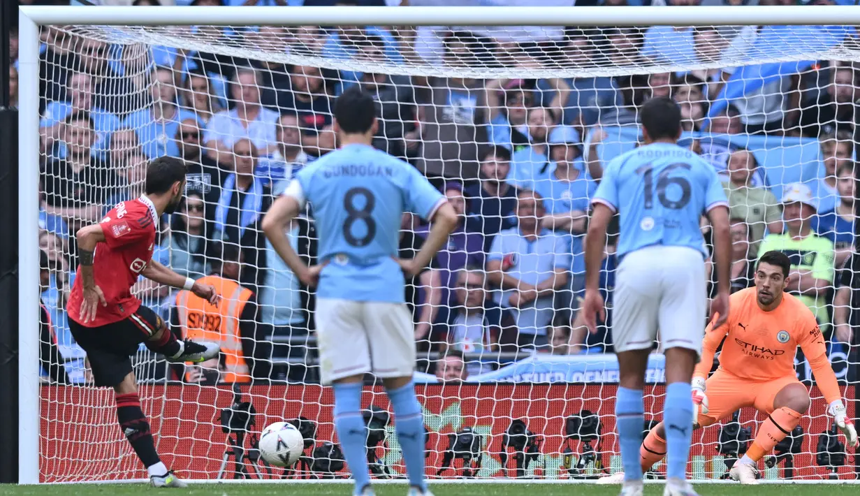 Pemain Manchester United, Bruno Fernandes (kiri), berhasil membuat imbang kedudukan menjadi 1-1 setelah berhasil mencetak gol dari titik penalti ke gawang Manchester City dalam pertandingan final FA Cup 2022/2023 yang berlangsung di Wembley Stadium, Sabtu (3/6/2023). (AFP/Glyn Kirk)