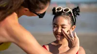 Seorang Ibu Sedang Mengoleskan Sunscreen Pada Anak (freepik)