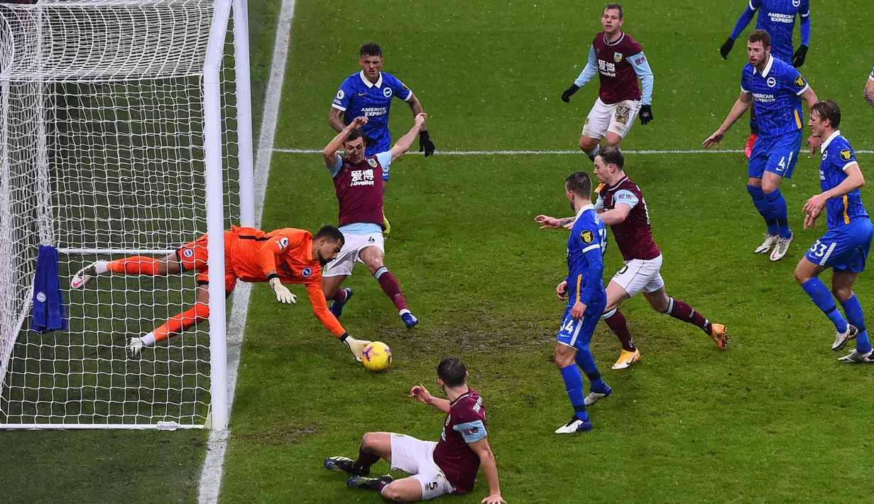 Penjaga gawang Brighton, Robert Sanchez tak gentar menghentikan bola dari serangan sejumlah pemain Burnley. (Foto: AFP/Pool/Laurence Griffiths)