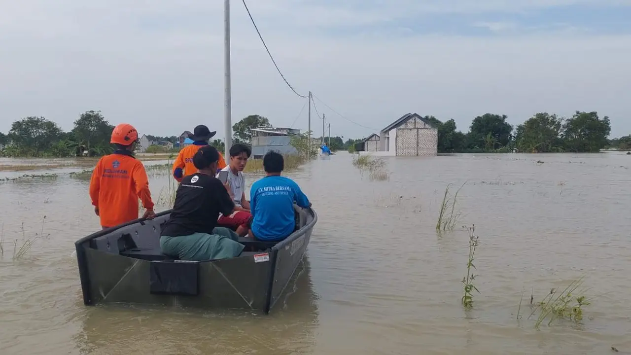 Petugas BPBD Gresik mengevakuasi korban banjir ke lokasi aman. (Istimewa)
