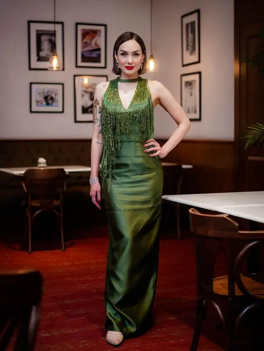 Lawan main Amanda, Sara Wijayanto juga tak kalah glamor. Ia mengenakan gaun v-neck berwarna hijau satin rancangan @pamelausanto.atelier. Detail sematan fringe di bagian atas gaun bikin ia tampil shinny..