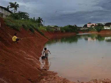 Anak-anak memancing pada bagian proyek pembangunan tol Cinere-Serpong yang berubah menjadi danau sedalam 4 meter di kawasan Cipayung, Tangsel, Banten (17/1). Pembangunan jalan Tol ini sepanjang 10,14 kilometer. (Merdeka.com/Arie Basuki)