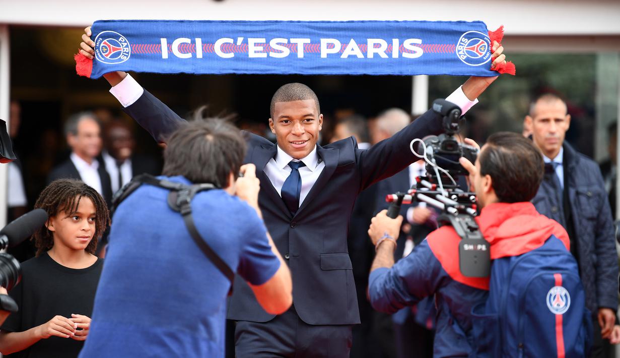 Pemain baru PSG, Kylian Mbappe memegang saat perkenalan dirinya di Parc des Princes stadium, Paris, (6/9/2017). Mbappe dipinjam PSG dari Monaco dengan opsi permanen sebesar 180 juta euro tahun berikutnya. (AFP/Franck Fife)