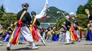 Penampil menari dekat Kompleks Blue House sehari setelah dibuka untuk umum menyusul janji kampanye Presiden Korea Selatan Yoon Suk-yeol di Seoul, Korea Selatan, 11 Mei 2022. (ANTHONY WALLACE/AFP)