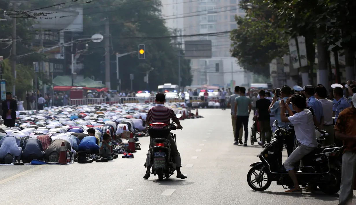 Warga muslim Shanghai melaksanakan Salat Idul Adha di jalan di luar sebuah masjid di Shanghai, Tiongkok, Senin (12/9). (REUTERS / Aly Lagu)
