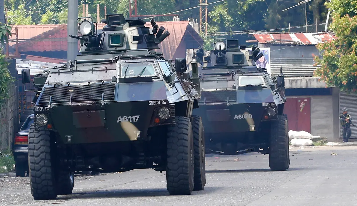 Dua kendaraan militer Filipina (AFV) saat mengambil posisi memerangi militan Maute di kota Marawi, Filipina, (28/5). Sekitar 100 ribu warga Marawi meninggalkan rumahnya akibat pertempuran yang berlangsung. (AP Photo/Bullit Marquez)