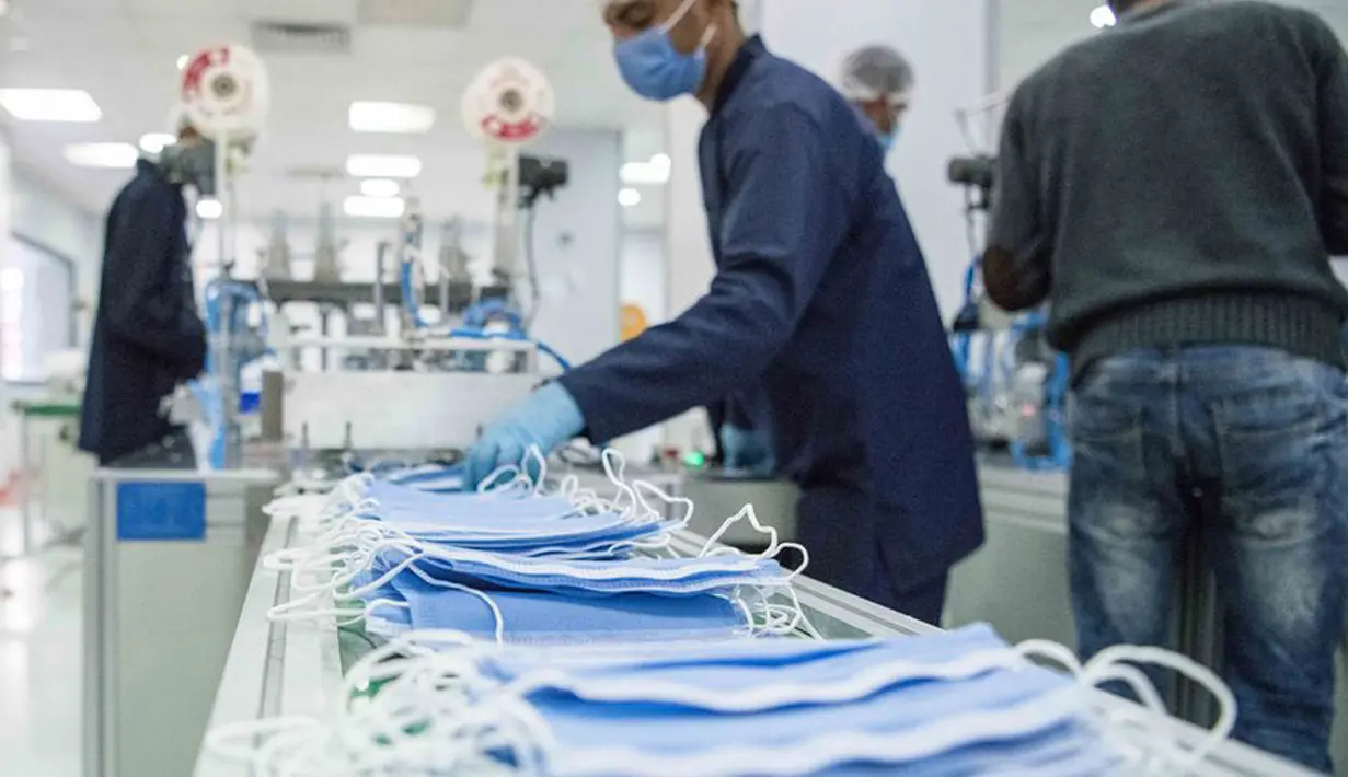 Orang-orang bekerja di sebuah pabrik yang memproduksi masker medis di Kairo, Mesir, 14 April 2020. Para karyawan bekerja siang dan malam untuk mengoperasikan lima mesin canggih yang dibawa dari China untuk memproduksi hingga 750.000 masker medis per hari. (Xinhua/Wu Huiwo)