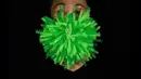 Edmond Kok, desainer dan aktor kostum teater Hong Kong, mengenakan topeng hijau runcing yang merupakan visualisasi 3D virus corona di Hong Kong pada 6 Agustus 2020. Edmond telah membuat lebih dari 170 masker yang terinspirasi oleh pandemi dan masalah politik Hong Kong. (AP Photo/Vincent Yu)