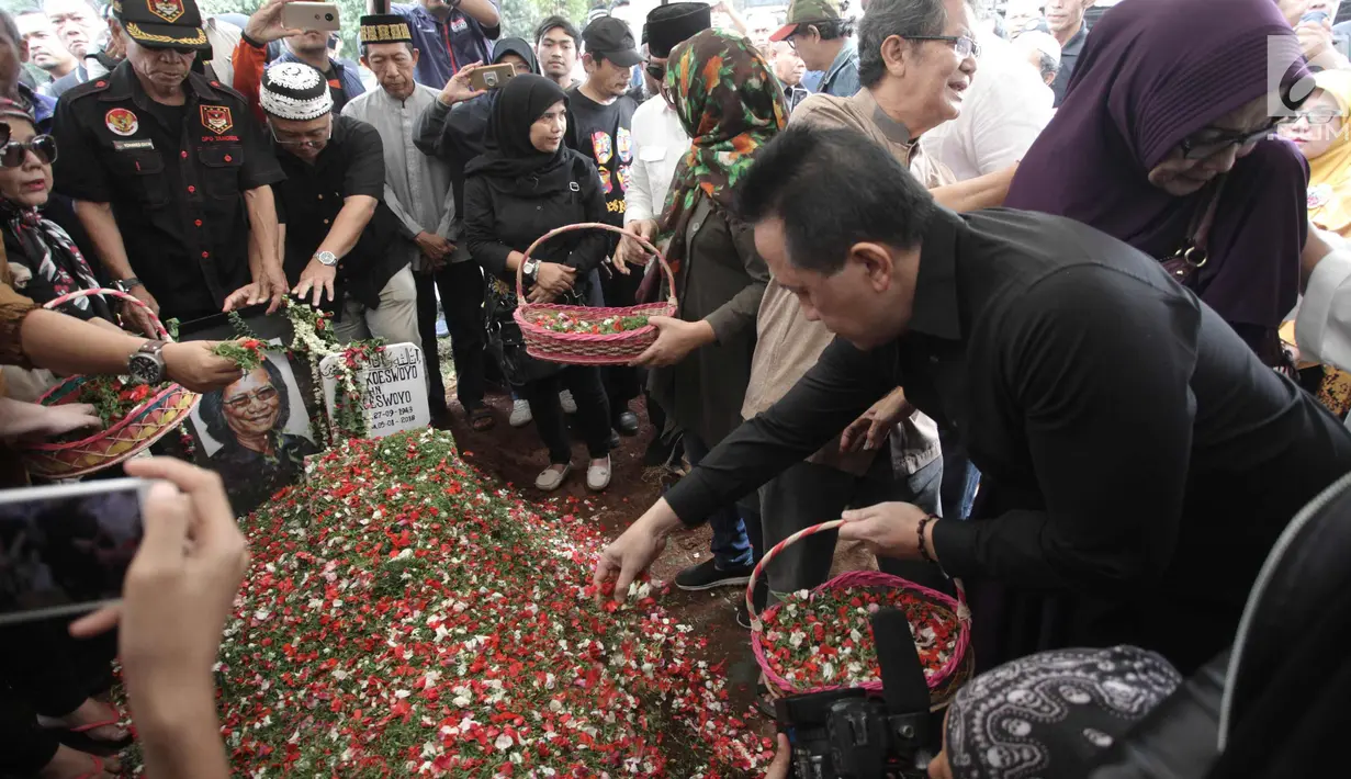 Keluarga dan kerabat menaburkan bunga di atas makam Yon Koeswoyo di TPU Tanah Kusir, Jakarta Selatan, Sabtu (6/1).   Yon Koeswoyo meninggal dunia pada usianya yang ke-77 tahun karena menderita sakit komplikasi. (Liputan6.com/Arya Manggala)