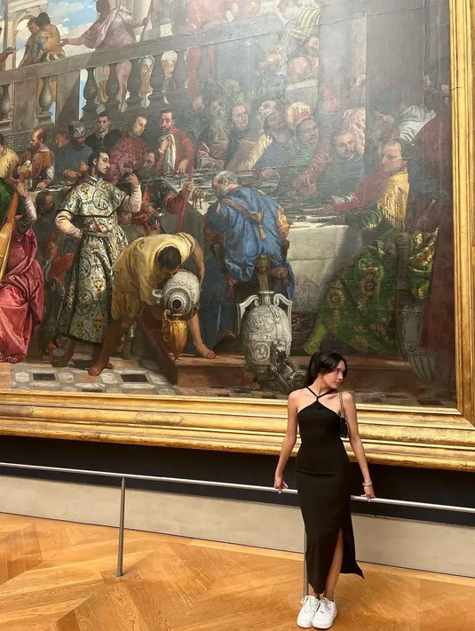 Mampir ke Museo del Louvre, Beby Tsabina pun memilih tampil elegan dengan hatlerstrap dress. Dress berwarna hitam ini sangat pas di tubuh Beby dan dipadukan dengan sneakers putih (instagram/bebytsabina)