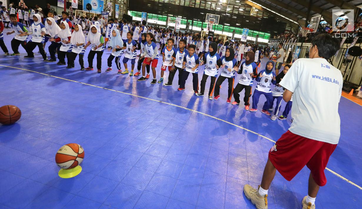 Pelatih memberikan pemanasan kepada anak-anak pada program Junior NBA Indonesia di Cilandak, Jakarta, Sabtu (24/3). Kegiatan yang didukung Frisian Flag diharapkan mampu menjangkau lebih dari 12.000 anak-anak. (Liputan6.com/Fery Pradolo)