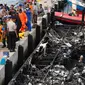 Petugas kepolisian bersama Tim SAR gabungan mengevakuasi kantong jenazah korban kapal Zahro Express yang terbakar, di Pelabuhan Muara Angke, Minggu (1/1). Sejumlah jenazah ditemukan dengan kondisi hangus terbakar dari kapal. (REUTERS/Darren Whiteside)