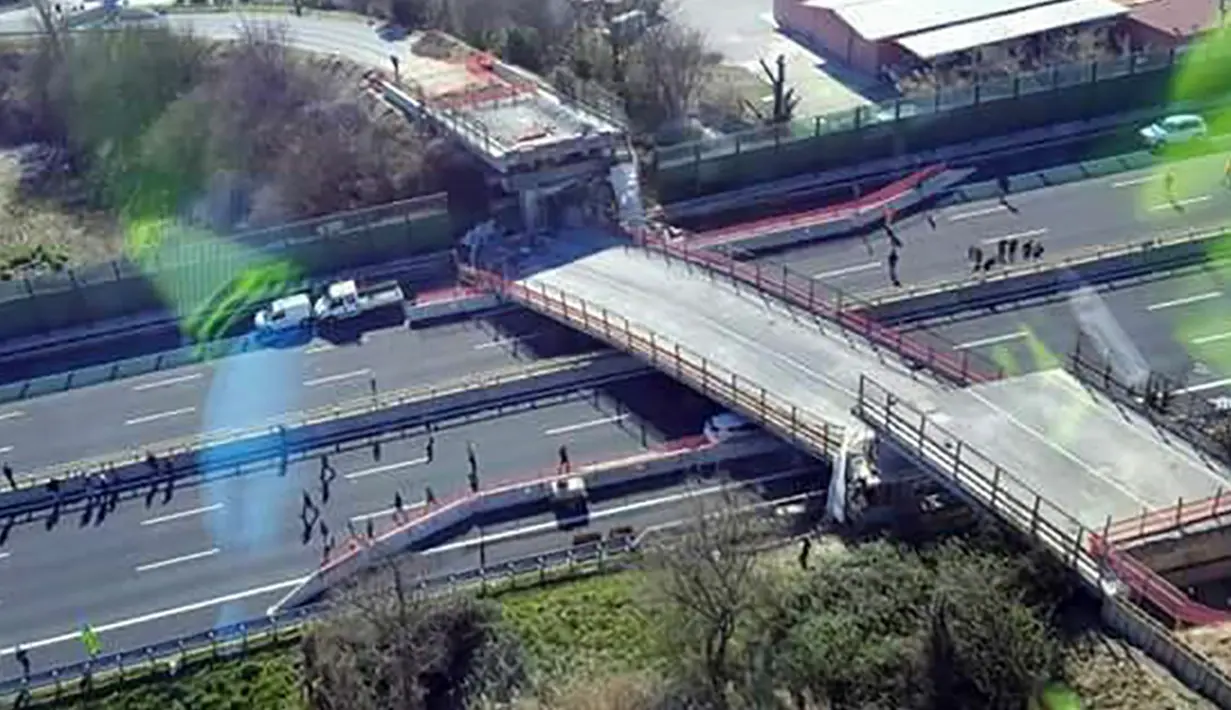 Jembatan roboh di Ancona melintang di atas ruas jalan tol di wilayah pesisir pantai Italia, Kamis (9/3). Selain menewaskan sepasang suami istri, peristiwa tersebut turut melukai dua orang lainnya yang merupakan pekerja konstruksi (HO/Polizia di Stato/AFP)