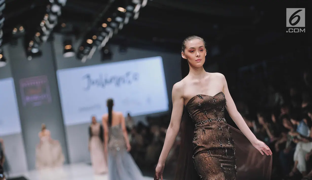 Model berjalan di atas catwalk membawakan busana dari siswa Istituto di Moda Burgo (IMB), Julianto di Jakarta Fashion Week 2018, Jakarta, Jumat (27/10). Payet, mutiara membentuk garis-garis menghiasi koleksi Julianto. (Liputan6.com/Faizal Fanani)