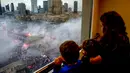 Anak-anak menonton dari jendela ketika ribuan orang berkumpul di pusat kota untuk pawai Hari Kemerdekaan tahunan di Warsawa, Polandia, 11 November 2022. Pawai diselenggarakan oleh kelompok-kelompok nasionalis yang telah ditandai dengan kekerasan dalam beberapa tahun terakhir. (AP Photo/Michal Dyjuk)