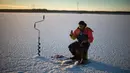 Seorang pria berusaha memancing ikan di laut Bothnia yang sedang membeku, Vaasa, Finlandia (29/12). Kebiasaan memancing di laut beku merupakan hal menantang yang ditunggu-tunggu oleh sebagian warga setempat. (AFP PHOTO/Olivier Morin)