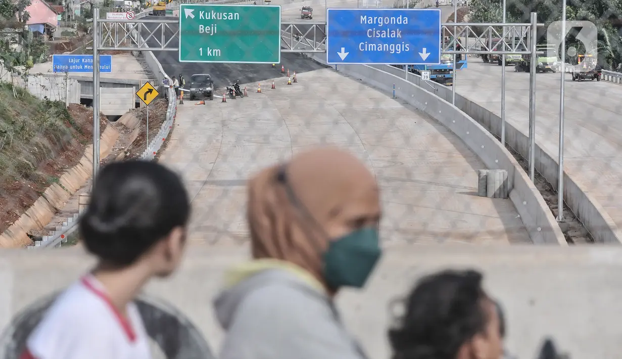 Warga melintas di jembatan yang berada di atas proyek Tol Cinere-Jagorawi (Cijago) seksi 3 ruas Kukusan-Cinere di kawasan Tanah Baru, Depok, Jawa Barat, Minggu (20/11/2022). Ditjen Binamarga Kementerian PUPR mengungkapkan progres pembangunan Tol Cijago seksi 3 yang menghubungkan Cinere-Jagorawi hampir rampung dan rencananya akan diuji coba pada libur Natal dan Tahun Baru. (merdeka.com/Iqbal S Nugroho)