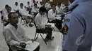 Seorang napi peserta UN menanyakan sesuatu kepada petugas saat UN 2015 digelar di LP Narkotika Cipinang, Jakarta, Senin (13/4/2015).  Para peserta terlihat bersemangat menjalani UN 2015. (Liputan6.com/Johan Tallo)