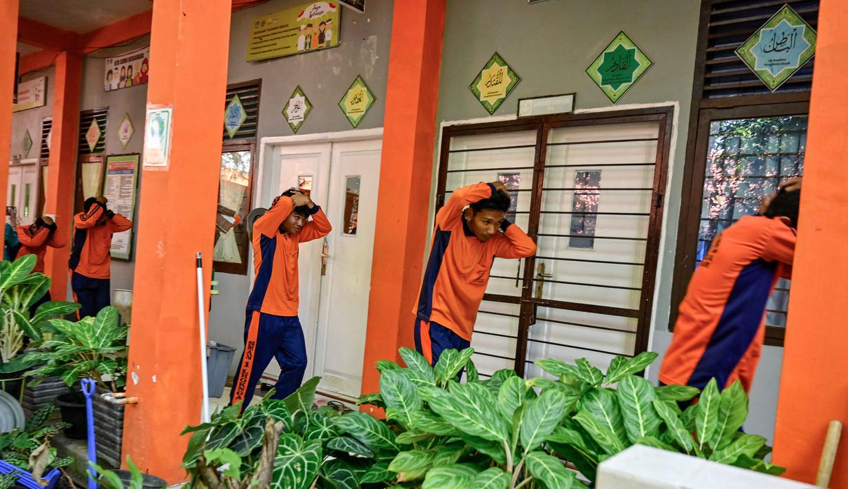 Sejumlah siswa Sekolah Menengah Atas (SMA) mengikuti simulasi gempa bumi dan tsunami untuk memperingati Hari Kesadaran Tsunami Sedunia di Lhoknga, Provinsi Aceh, pada Rabu 5 November 2025. Kegiatan ini menjadi pengingat pentingnya kesiapsiagaan masyarakat, terutama generasi muda, dalam menghadapi ancaman bencana alam. (CHAIDEER MAHYUDDIN/AFP)