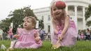 Abigail (3) bersama adiknya menggelindingkan telur saat lomba perayaan Paskah di halaman Gedung Putih, Washington, Senin (17/4). Lomba yang digelar setiap tahun di Gedung Putih ini merupakan lomba menggelindingkan telur yang ke-139. (SAUL LOEB / AFP)