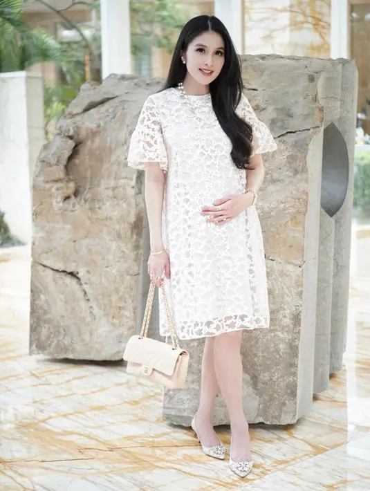 Aura cantik Sandra Dewi begitu terpancar dengan dress putih berbahan broukat ini. Tak ada aksen atau hiasan macam-macam, dress tersebut tampak sederhana dan elegan. (Instagram/sandradewi88)