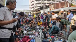 Sebagai informasi, cakupan Sensus Ekonomi 2026 adalah seluruh usaha ekonomi, termasuk usaha mikro/rumah tangga (pedagang pasar, warung, usaha online, industri tekstil, jasa, dll), kecuali sektor pertanian. Tampak dalam foto, orang-orang melihat-lihat barang bekas di salah satu ruas jalan, Surabaya, Jawa Timur, pada Minggu 19 April 2026. (JUNI KRISWANTO/AFP)