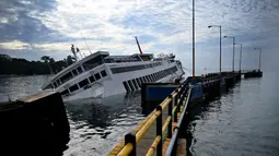 KMP Dharma Rucitra III kandas di Pelabuhan Padang Bai, Karangasem, Bali, Sabtu (13/6/2020). KMP Dharma Rucitra III diduga mengalami kebocoran lambung sehingga kehilangan keseimbangan. (SONNY TUMBELAKA/AFP)