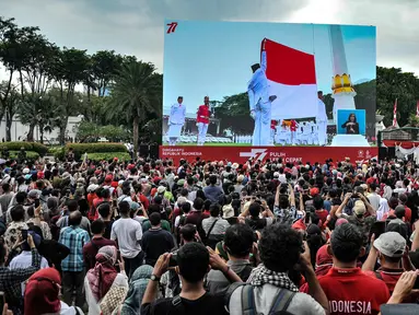 Warga memberikan hormat saat pengibaran bendera Merah Putih dalam Upacara HUT ke-77 Republik Indonesia yang disaksikan dari Taman Aspirasi Monumen Nasional (Monas), Rabu (17/8/2022). Setelah sempat ditiadakan selama 2 tahun akibat pandemi Covid-19, Upacara Peringatan Kemerdekaan Republik Indonesia disambut antusias warga dari berbagai daerah yang berdatangan untuk mengikuti meski hanya dari luar Istana Negara. (merdeka.com/Iqbal S Nugroho)
