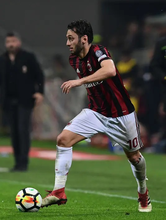 Gelandang AC Milan Hakan Calhanoglu mengontrol bola saat melawan Inter Milan dalam pertandingan Liga Italia di stadion San Siro, Milan (4/4). AC Milan tidak mampu mencetak gol saat menjamu Inter Milan. (AFP Photo / Miguel Medina)