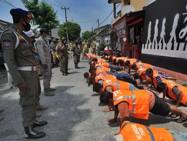 Puluhan pelanggar PSBB diberi hukuman push-up saat razia masker di Pasar Reni, Pamulang, Tangerang Selatan, Banten, Selasa (1/9/2020). Razia terhadap pedagang dan pengunjung pasar ini juga dilakukan rapid test guna mencegah penularan COVID-19. (merdeka.com/Arie Basuki)