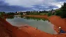 Anak-anak memancing pada bagian proyek pembangunan tol Cinere-Serpong yang berubah menjadi danau sedalam 4 meter di kawasan Cipayung, Tangsel, Banten (17/1). (Merdeka.com/Arie Basuki)