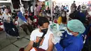 Tenaga kesehatan menyutikkan vaksin COVID-19 kepada warga di kawasan Pancoran, Jakarta (29/3/2022). Pemprov DKI Jakarta akan meningkatkan sentra vaksinasi jelang Ramadhan, hal itu dilakukan untuk meningkatkan percepatan vaksinasi booster sebagai syarat mudik 2022.(Liputan6.com/Herman Zakharia)