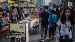 Warga melewati pedagang kaki lima (PKL) yang berjualan di kawasan car free day (CFD), Bundaran HI, Jakarta, Minggu (4/8/2019). Kurangnya pengawasan petugas menyebabkan banyak PKL berjualan tidak pada tempat yang telah disediakan oleh Pemprov DKI Jakarta. (Liputan6.com/Faizal Fanani)