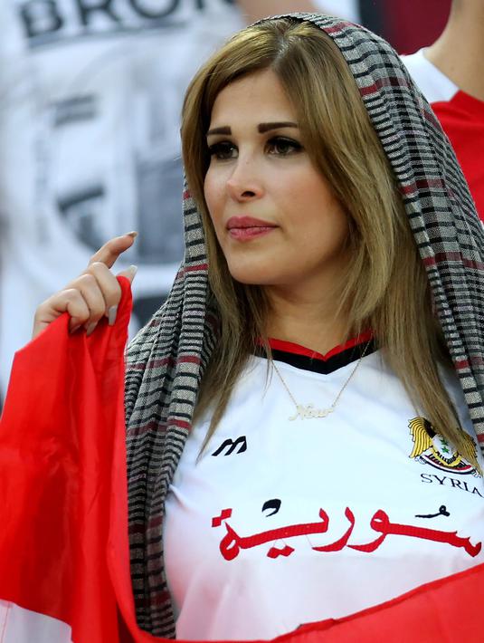 Seorang wanita cantik pendukung Suriah menyaksikan laga kualifikasi Piala Dunia 2018 melawan Iran di Stadion Azadi, Tehran, Selasa (5/9/2017). Finis urutan tiga grup A, Suriah lolos ke babak playoff untuk menantang Australia. (AFP/Atta Kenare)