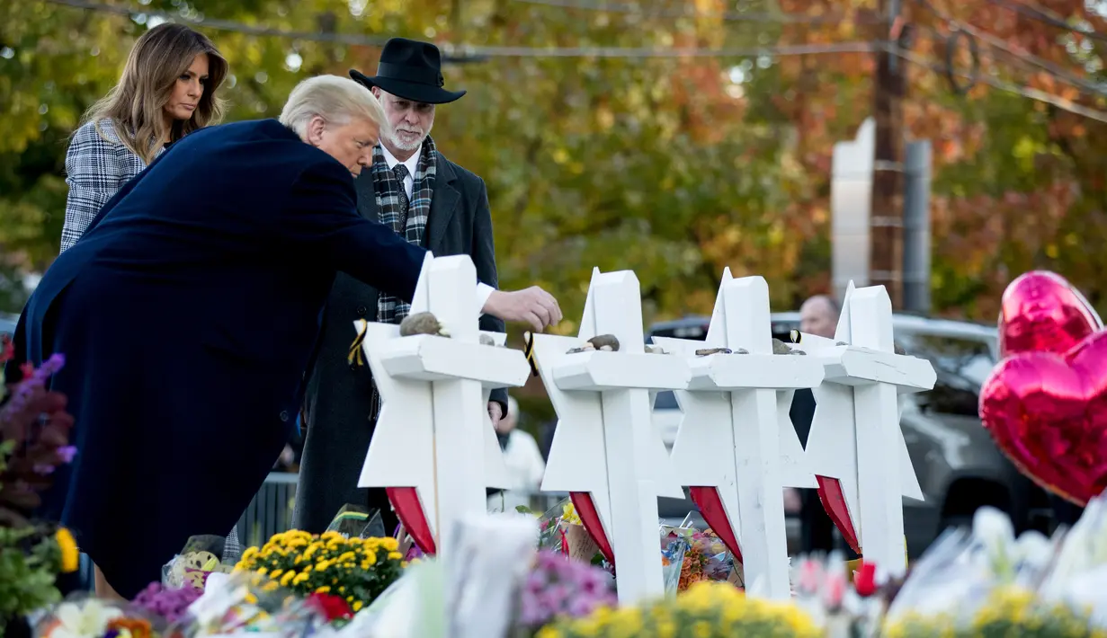 Presiden Donald Trump didampingi Melania Trump dan Rabbi Jeffrey Myers saat meletakkan batu dari Gedung Putih di monumen peringatan penembakan maut di sinagog Tree of Life, Kota Pittsburgh, Pennsylvania, AS, Selasa (30/10). (AP Photo/Andrew Harnik)
