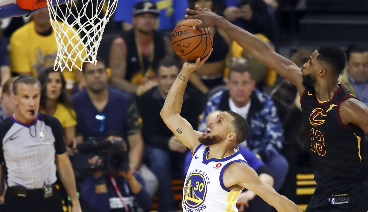 Pemain Cavaliers, Tristan Thompson (13) melakukan blok tembakan pemain Warriors, Stephen Curry (30) pada gim pertama final NBA basketball di Oakland, California, (31/5/2018). Warriors menang 124-114. (AP/Ben Margot)