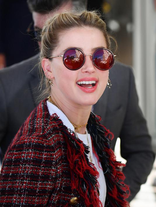 Aktris AS Amber Heard saat tiba untuk menghadiri malam pembukaan Festival Film Cannes ke-72 di Prancis (13/5/2019). Aktris 33 tahun ini mengenakan kaca mata merah, perhiasan emas, dan membawa tas rantai-tali YSL. (AFP Photo/Alberto Pizzoli)