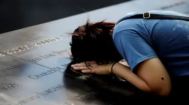 Seorang wanita meletakkan kepalanya saat melihat situs nama-nama para korban peristiwa serangan 11 September 2001 lalu di National September 11 Memorial and Museum at the World Trade Center, New York, Sabtu (10/9). (REUTERS/Mark Kauzlarich)