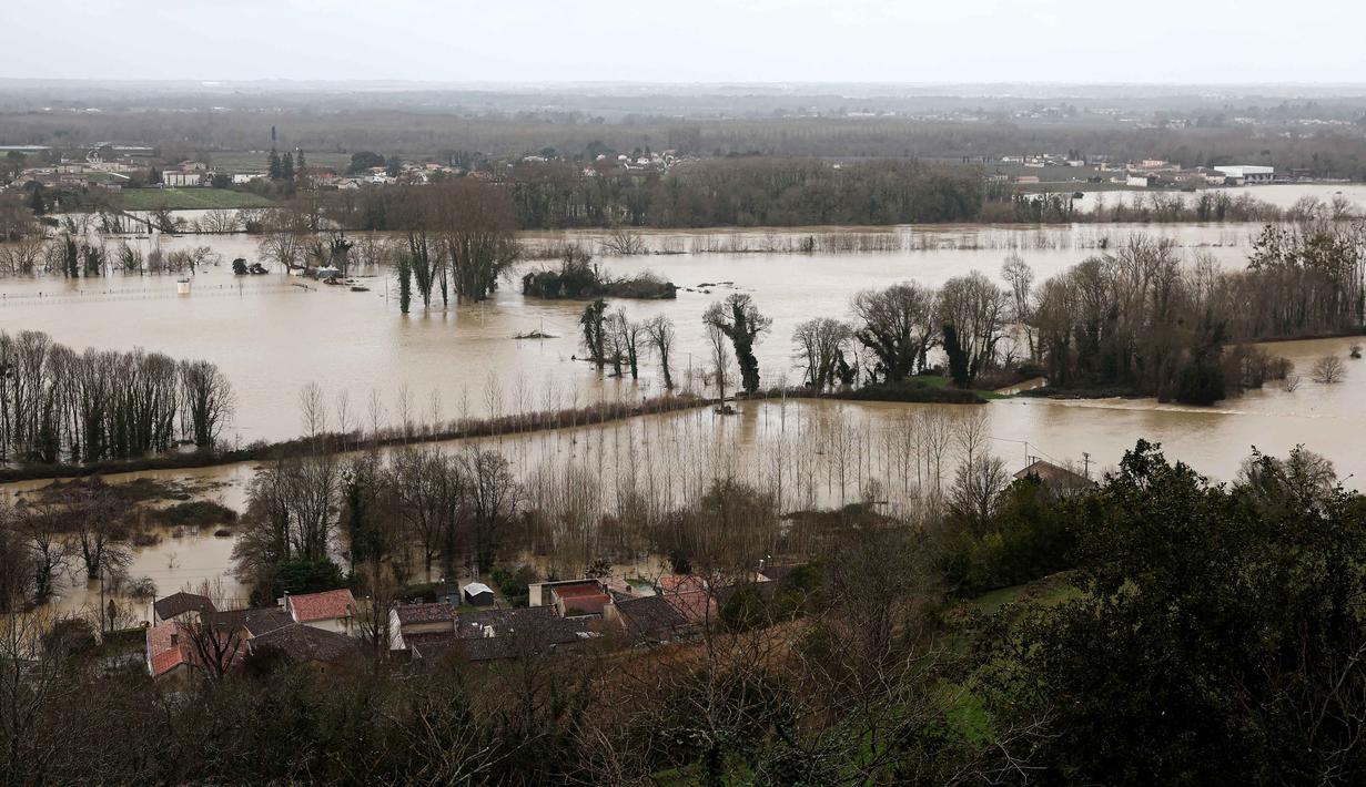 Curah hujan ekstrem selama lebih dari 35 hari berturut-turut, diperparah oleh Badai Nils dan Badai Pedro, memicu banjir yang mencapai level historis. Tampak foto menunjukkan kondisi rumah-rumah yang terendam banjir setelah hujan lebat yang menyebabkan banjir Sungai Garonne di Sainte-Croix-du-Mont, Prancis barat pada Kamis 19 Februari 2026. (ROMAIN PERROCHEAU/AFP)