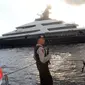 Petugas Polda Bali bersenjata laras panjang melakukan penjagaan saat kapal pesiar mewah (yacht) Equanimity terlihat berada di pelabuhan Benoa, Rabu (28/2). Equanimity juga disebut-sebut sebagai yacht terbesar ke-54 di dunia. (AP/Ambros Boli Berani)