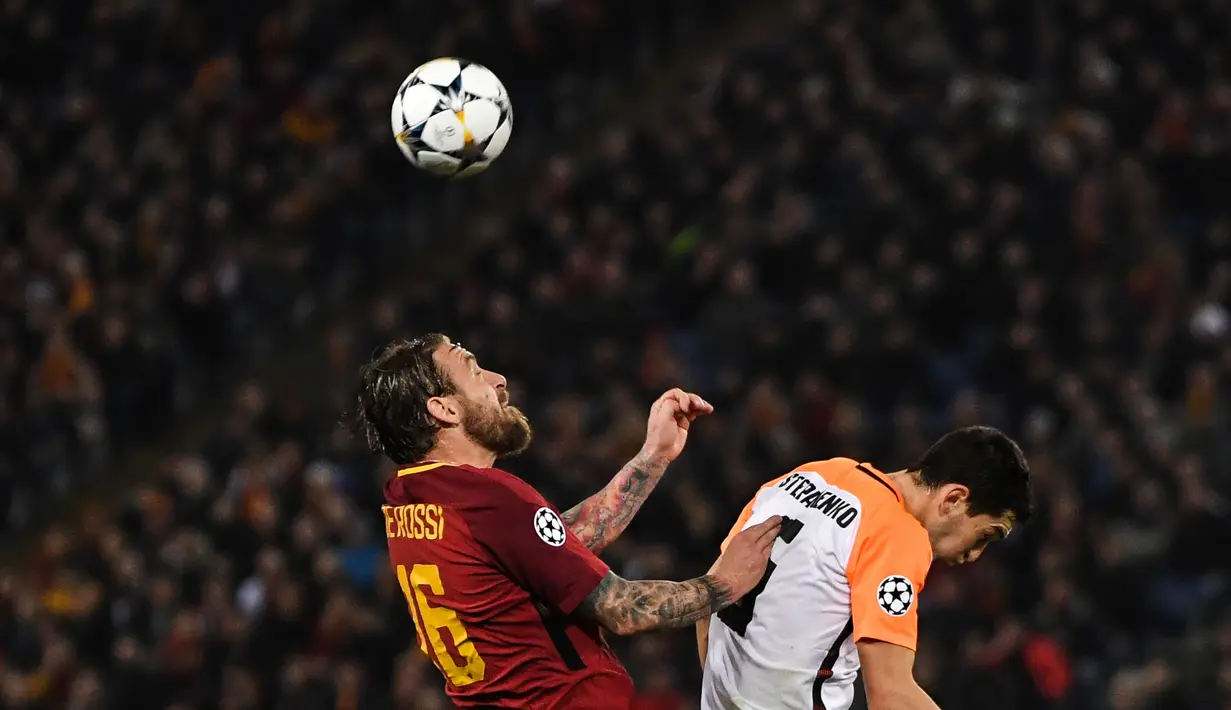 Gelandang AS Roma, Daniele De Rossi merebut bola dari pemain Shakhtar Donetsk, Taras Stepanenko pada leg kedua 16 besar Liga Champions 2017-2018  di Stadion Olimpico, Rabu (14/3). AS Roma melaju ke perempatfinal usai menang 1-0. (Filippo MONTEFORTE/AFP)