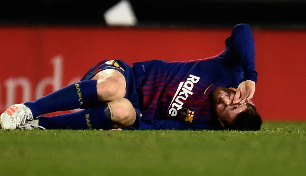 Pemain Barcelona, Lionel Messi berbaring di lapangan selama lanjutan La Liga Primera Division kontra Valencia di Stadion Mestalla, Minggu (26/11). Valencia memaksa Barcelona meraih hasil imbang 1-1.  (AFP PHOTO / JOSE JORDAN)