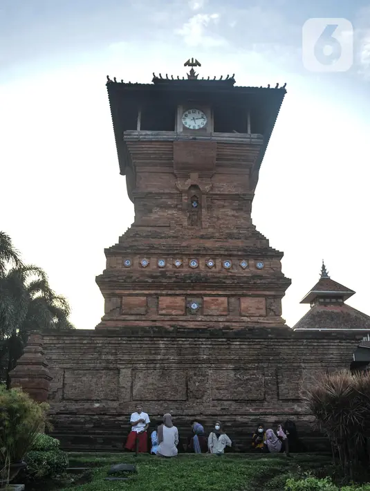 Peziarah bersantai di dekat Menara Kudus, Kauman, Kabupaten Kudus, Jawa Tengah, Rabu (30/3/2022). Menara berusia 473 tahun yang dahulu berfungsi sebagai tempat mengumandangkan azan menjadi lokasi favorit pengunjung untuk bersantai usai berziarah di Makam Sunan Kudus. (merdeka.com/Iqbal S. Nugroho)